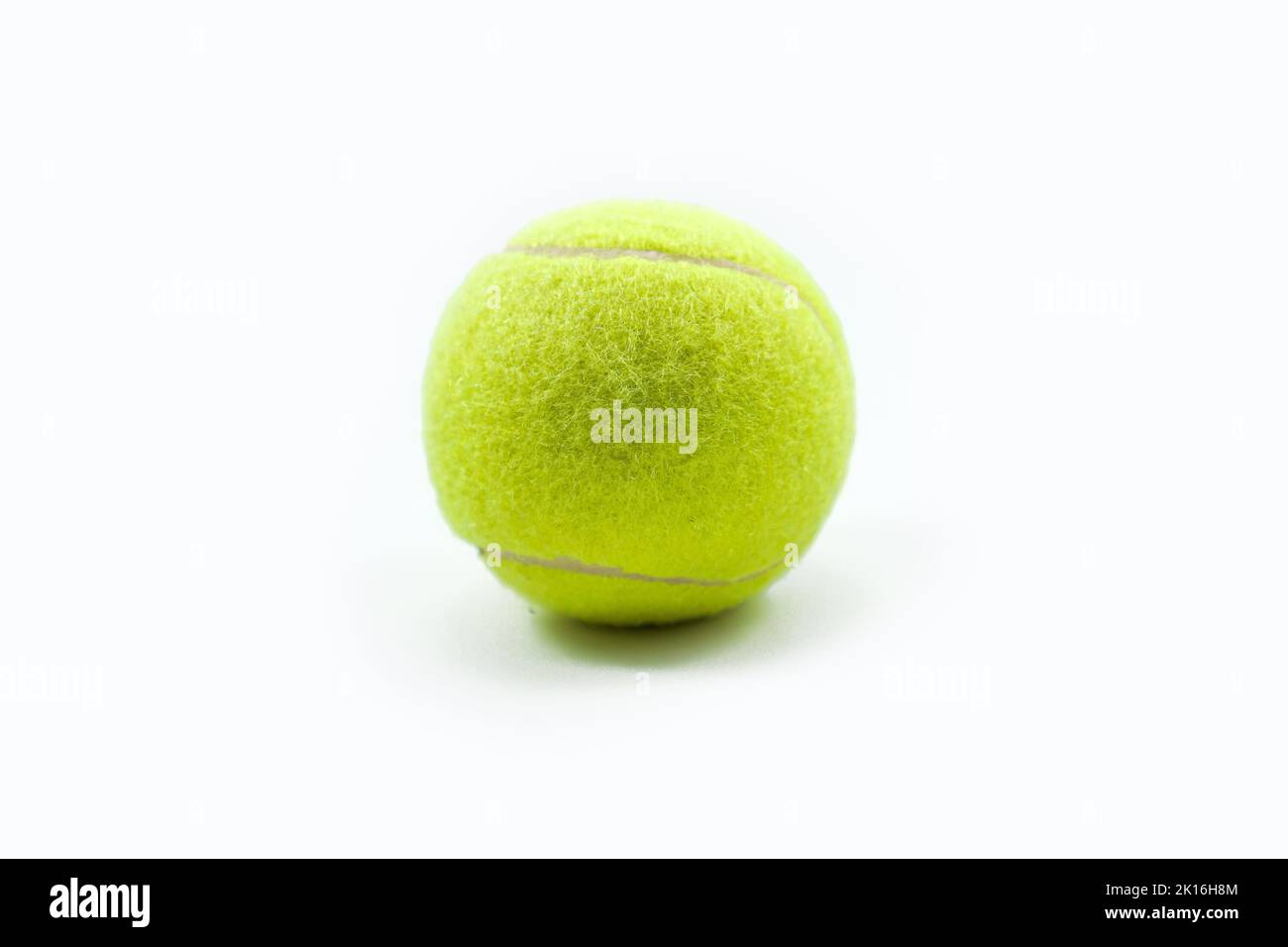 Yellow tennis ball made of felt and rubber isolated on a white