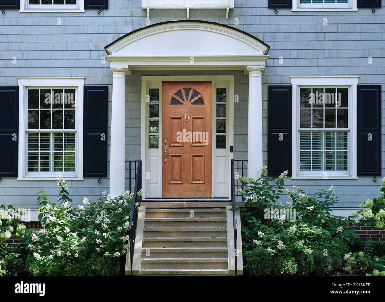 Front door of traditional two story suburban clapboard house with shutters Stock Photo