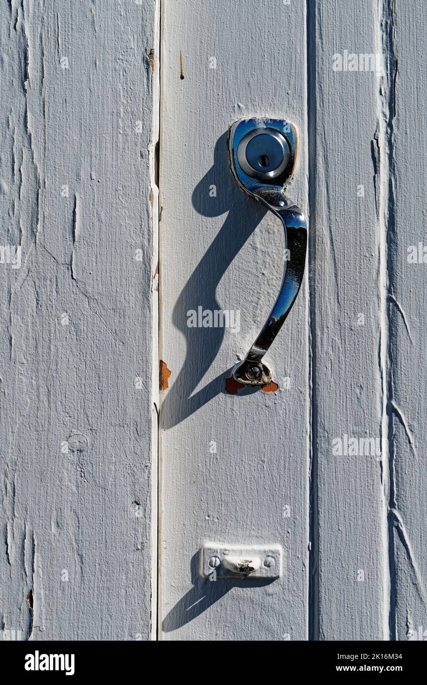 Door lock on an industrial building with a chrome handle. An eye below