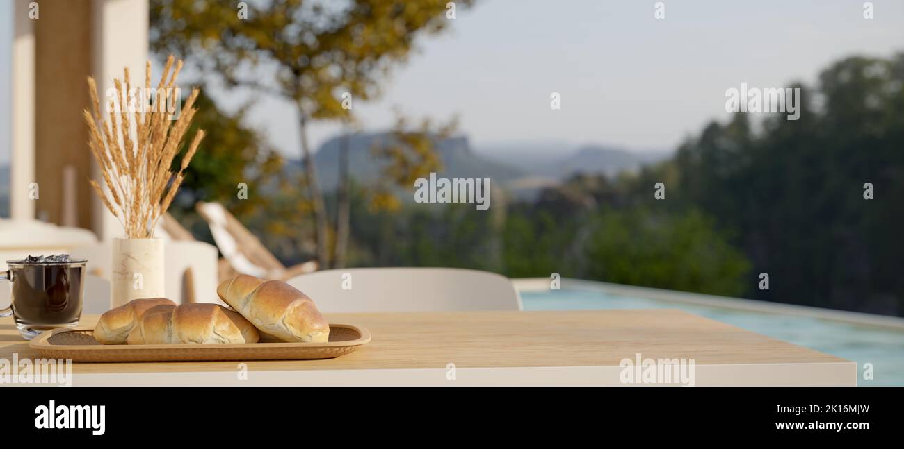 Copy space for product display on wood table with breakfast set and decor over blurred swimming pool with beautiful nature view in the background. Poo Stock Photo