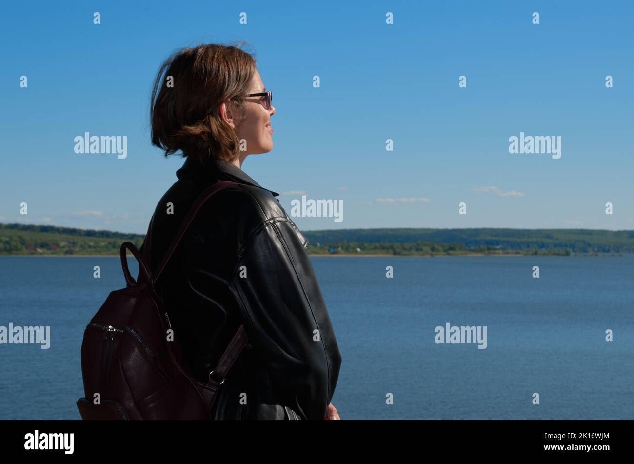 Portrait of woman in leather clothes on summer riverbank Stock Photo ...