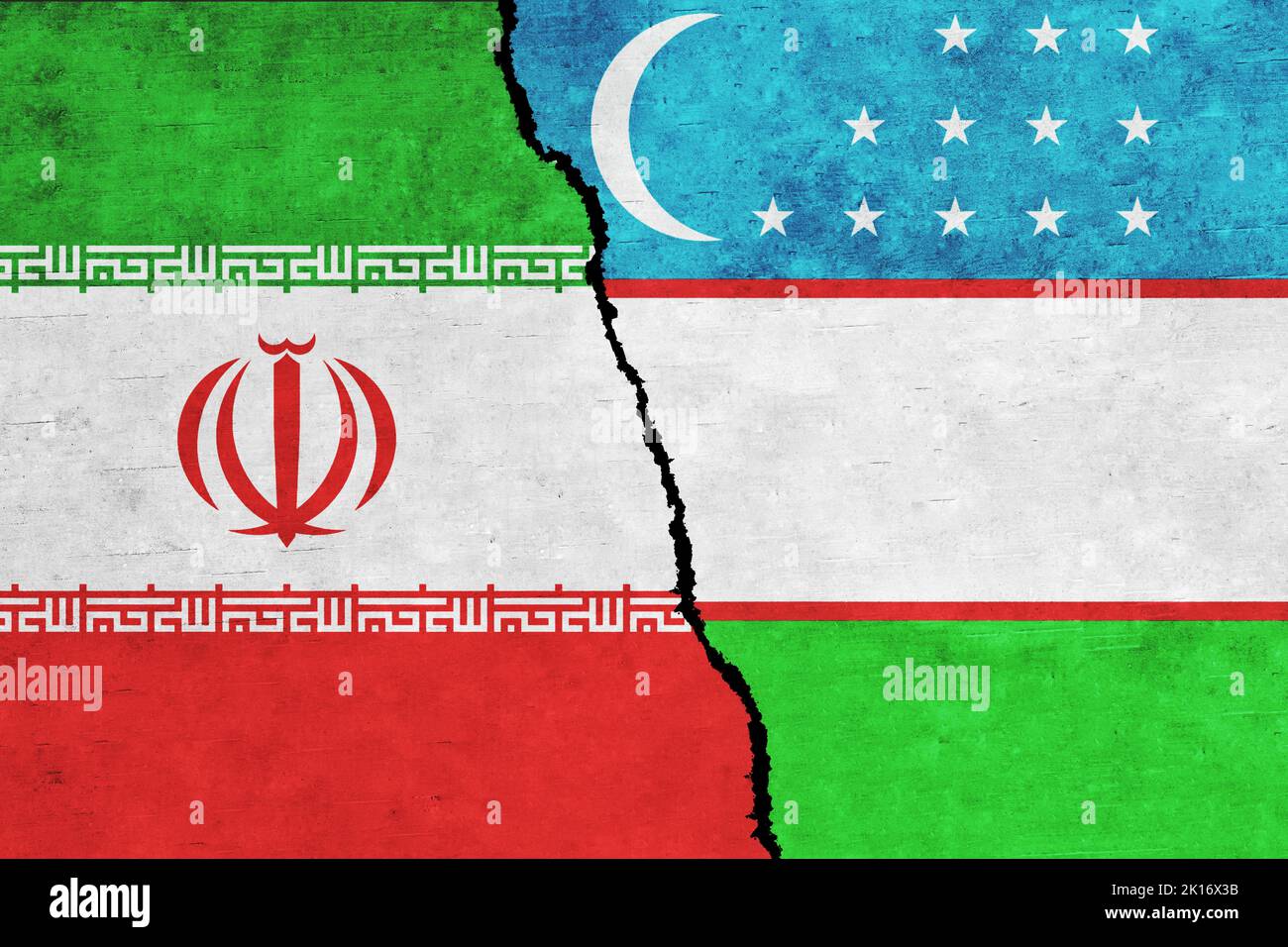 Iran and Uzbekistan painted flags on a wall with a crack. Iran and