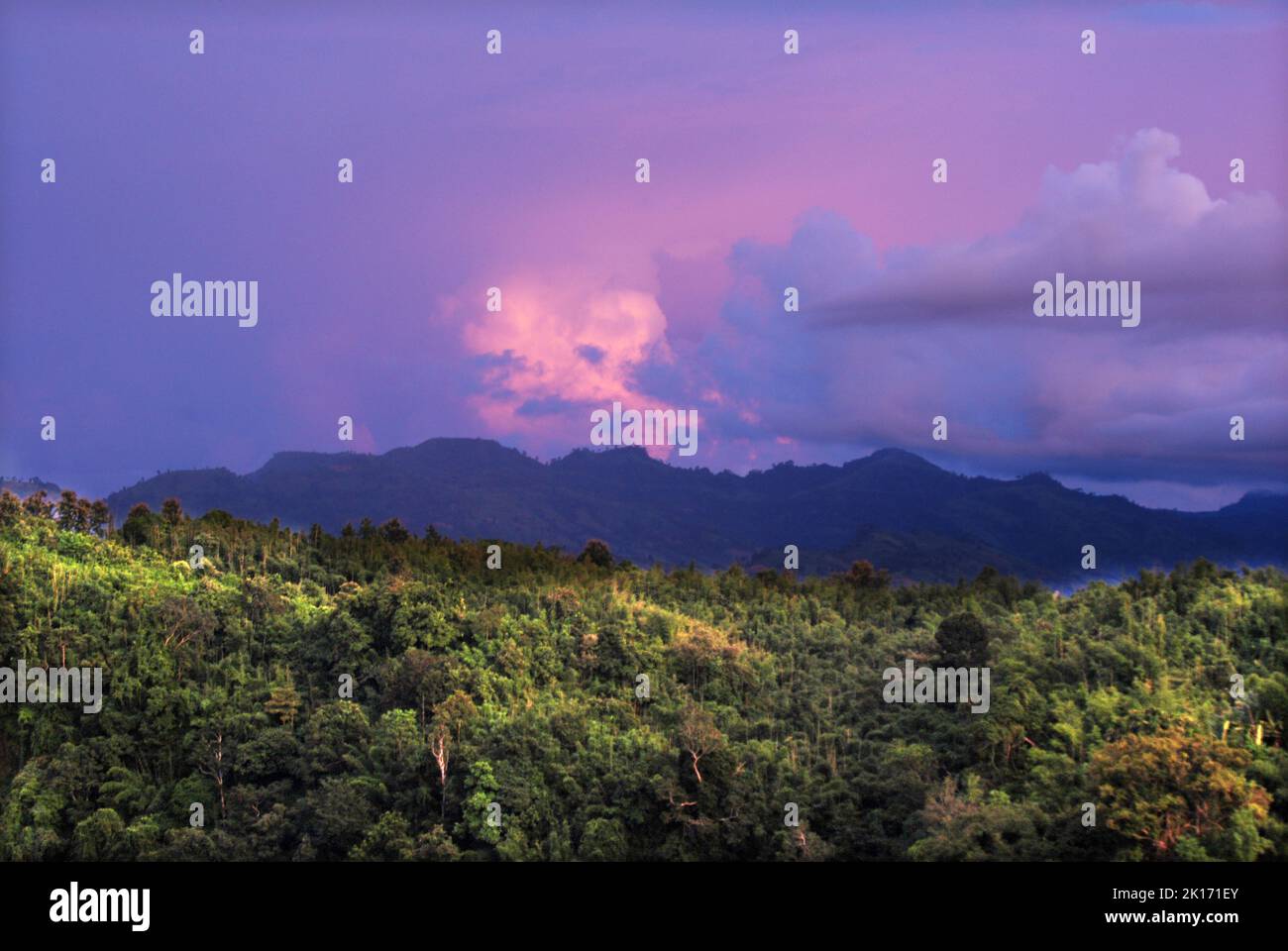 A bird's eye view of mountains covered with green forests at a cloudy ...