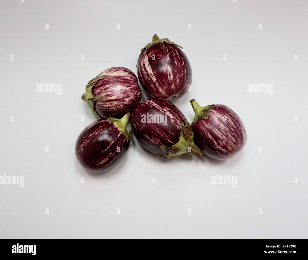 Purple and white striped aubergines on white background with copy space Stock Photo