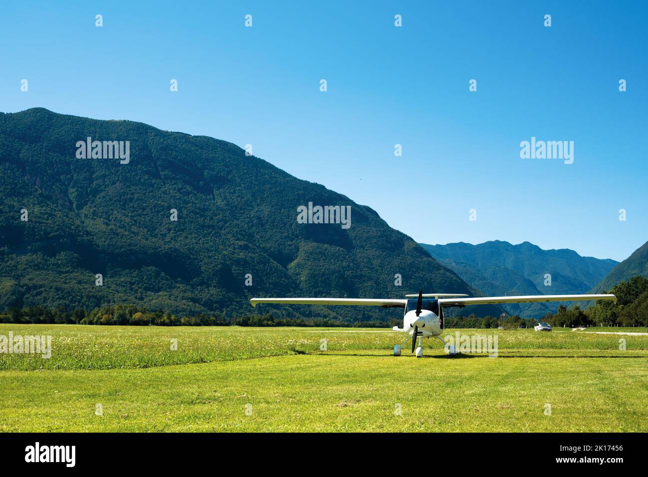 Small plane landed on green airfield in alps Stock Photo