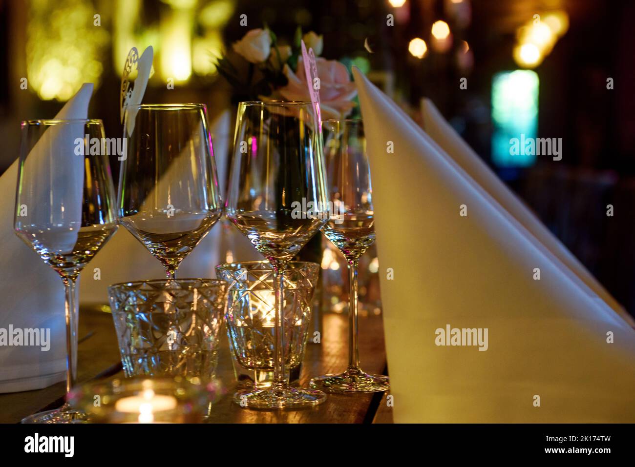 https://c8.alamy.com/comp/2K174TW/closeup-of-a-set-up-table-with-wine-glasses-and-a-white-serviette-on-a-wooden-table-2K174TW.jpg