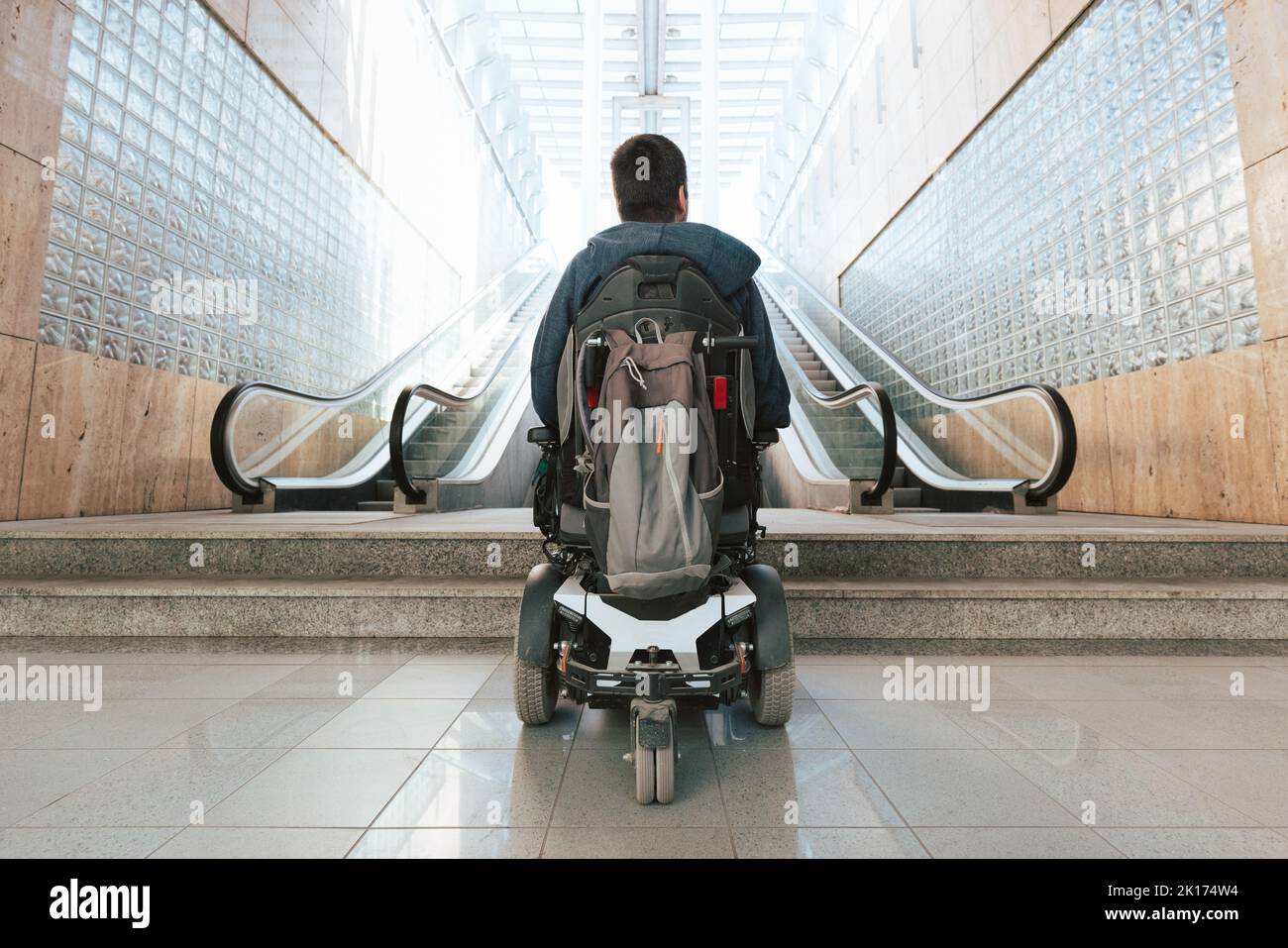 Man with disability on wheelchair stopped in front of staircase