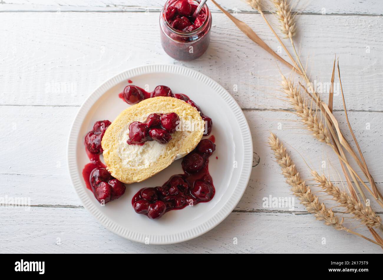 Cherry dessert with sour cherry compote and swiss roll filled with