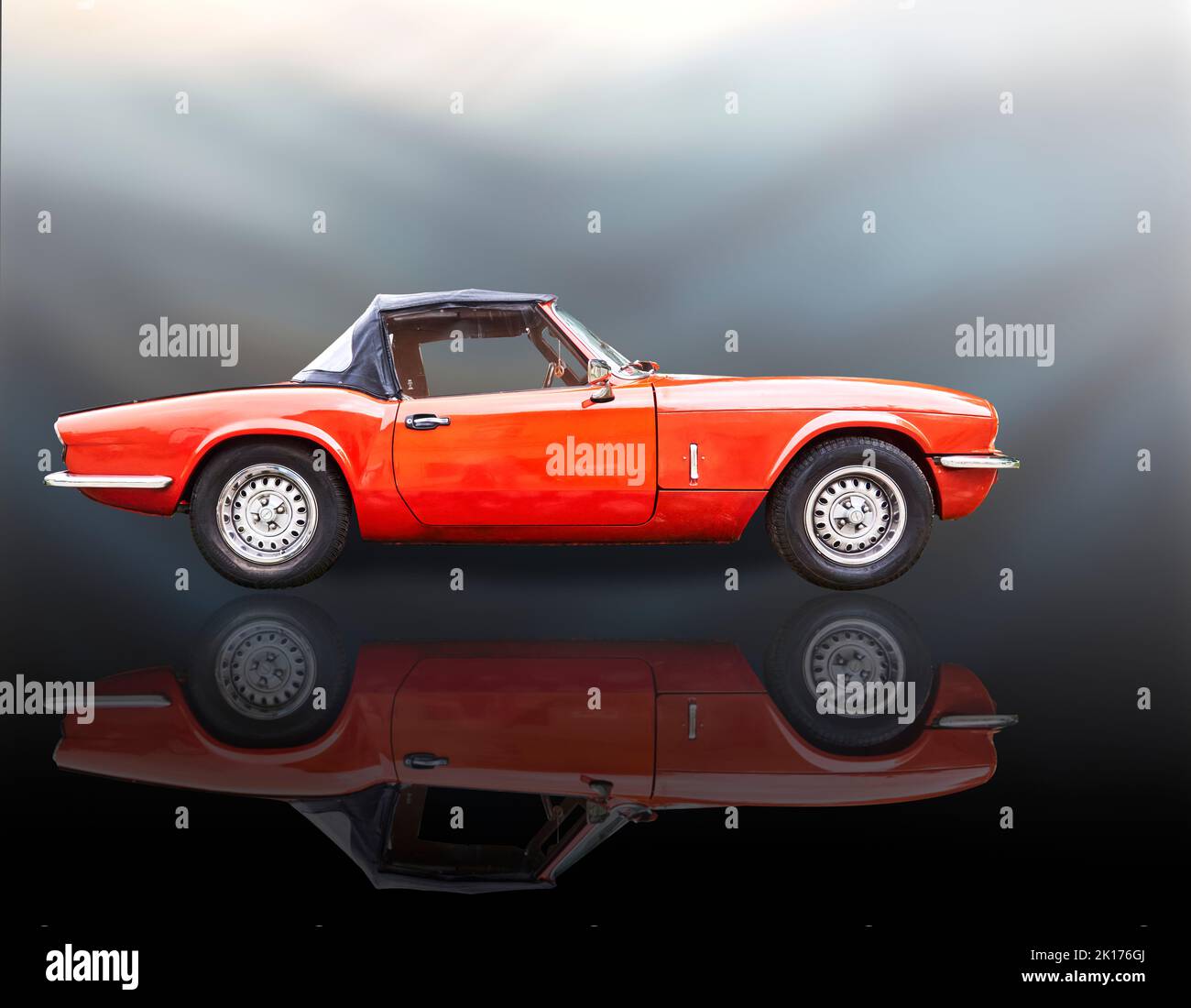 Triumph Spitfire sports car, side view of red convertible with reflection, Vehicle location Lehnin, Germany, September 11, 2022. Stock Photo