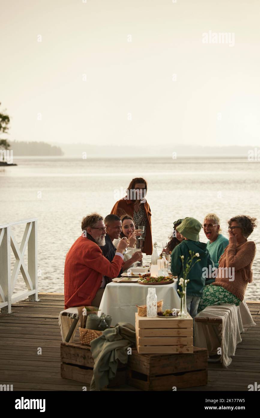Family having meal at lake Stock Photo