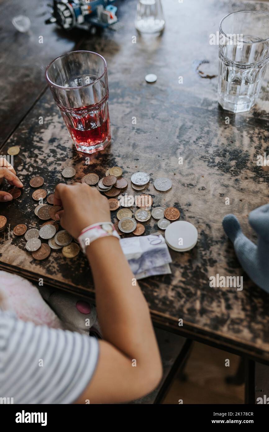 Child counting coins on table Stock Photo