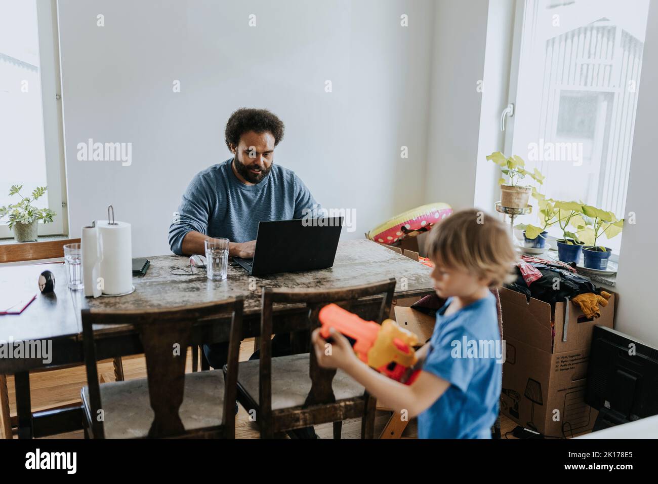 Man working from home and taking care of child Stock Photo