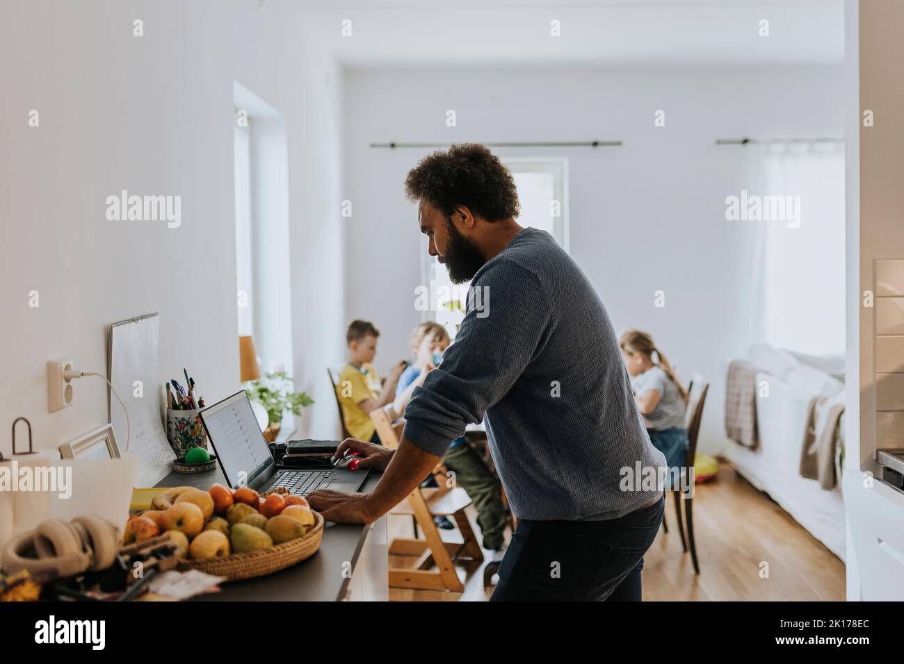 Man working from home and taking care of children Stock Photo