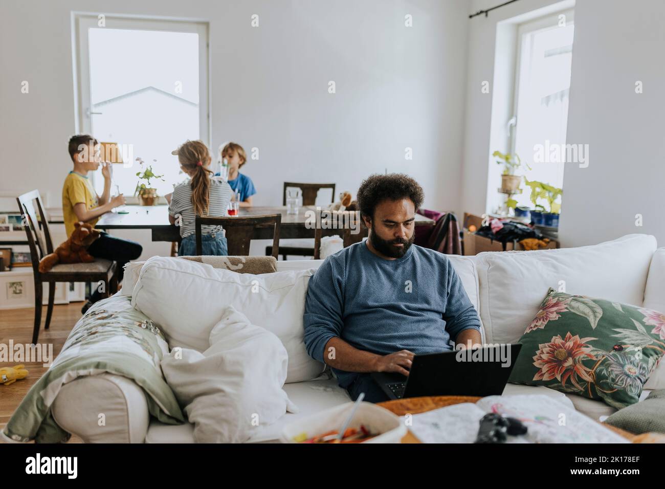 Man working from home and taking care of children Stock Photo