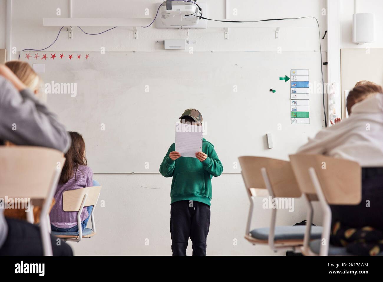 Boy reading in front of class Stock Photo