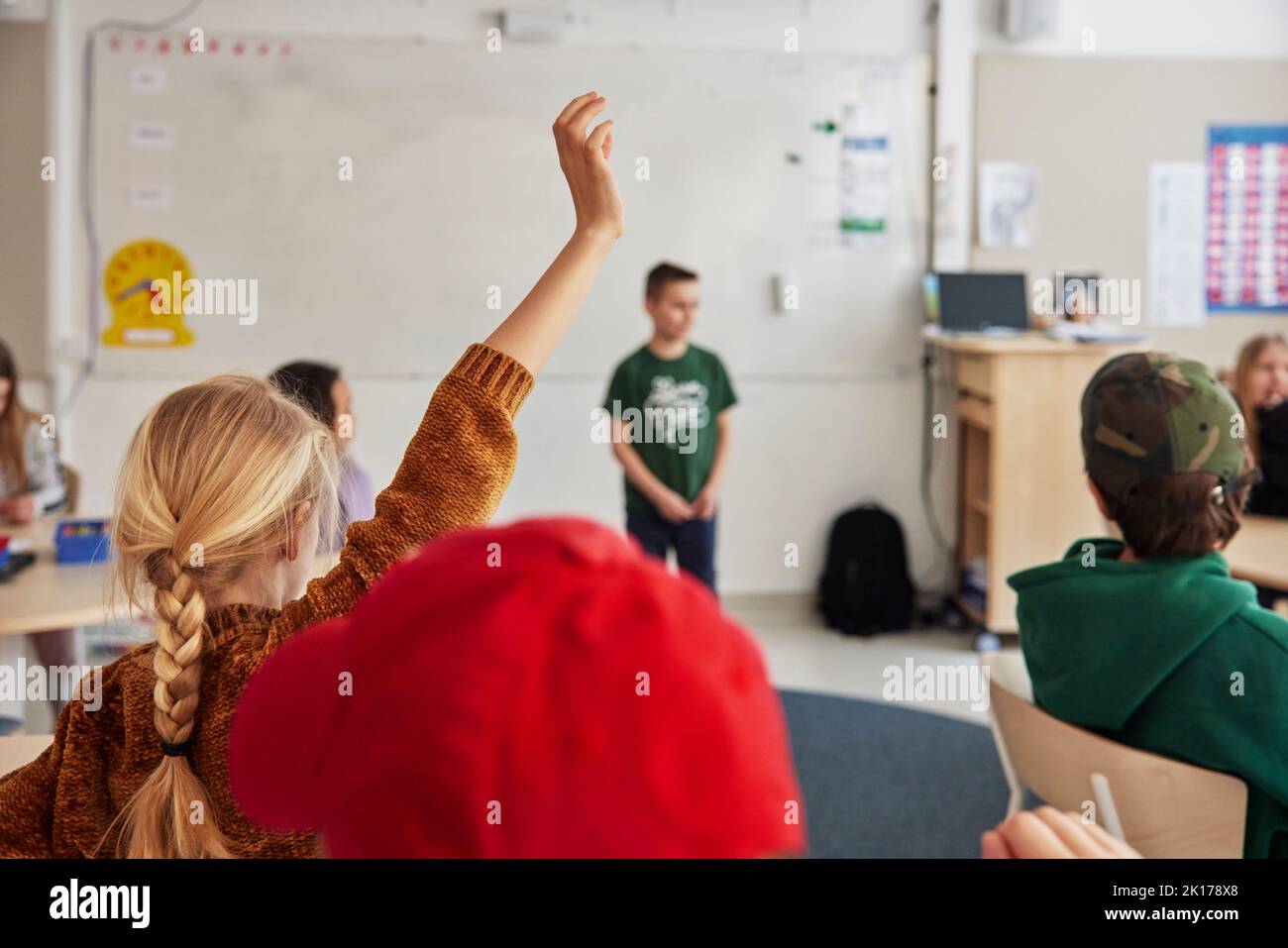 Girl with raised hand in classroom Stock Photo Alamy
