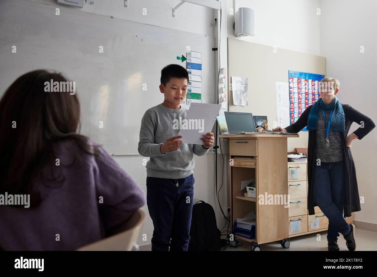 Boy reading in front of class Stock Photo