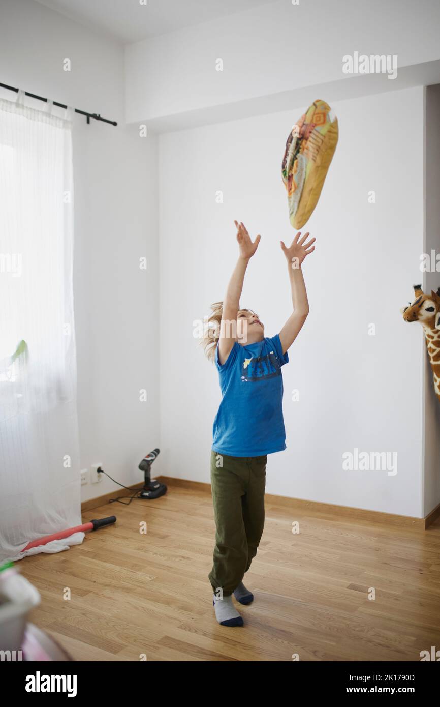 Boy throwing pillow in air Stock Photo