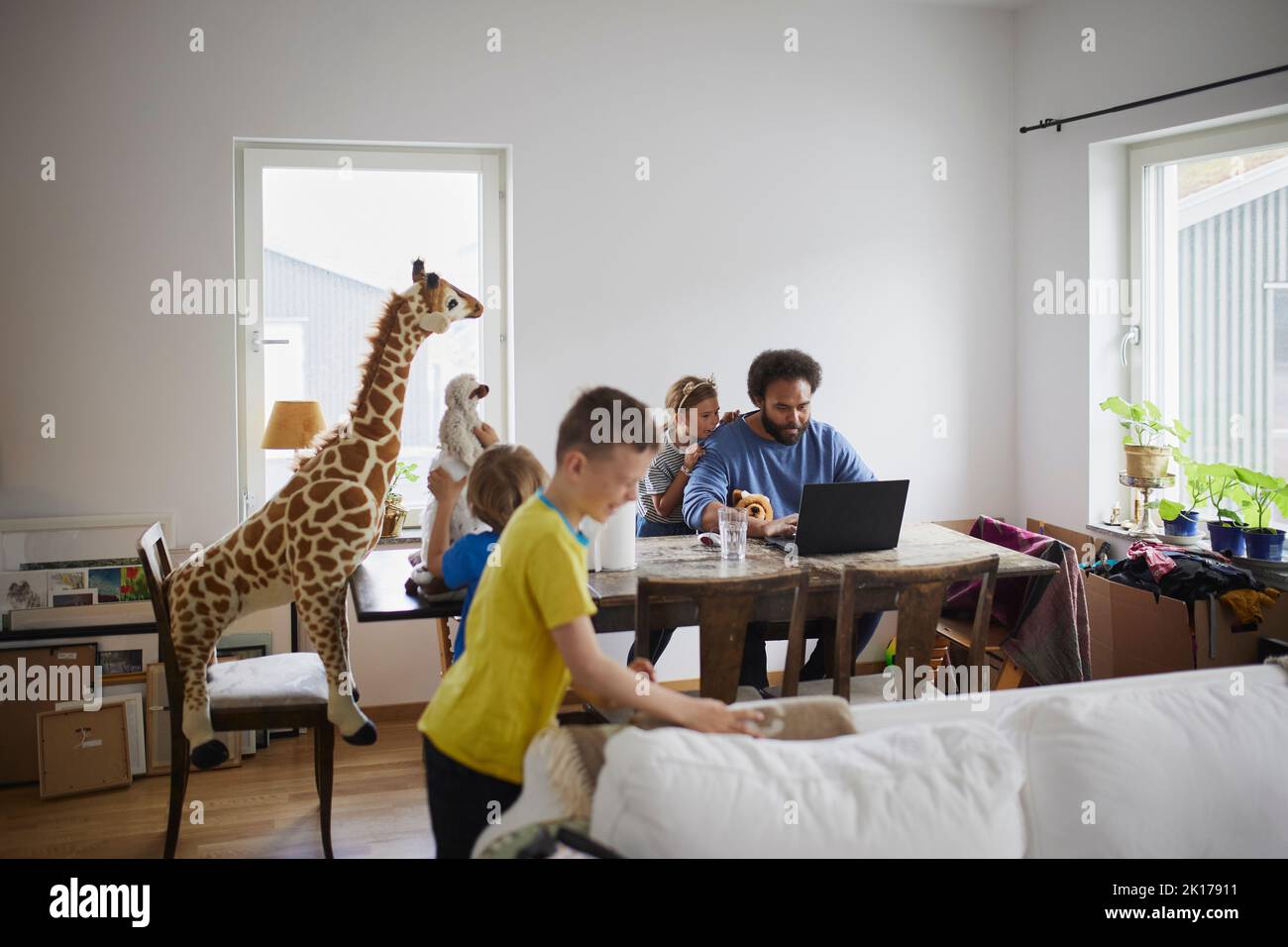 Father working from home and taking care of children Stock Photo