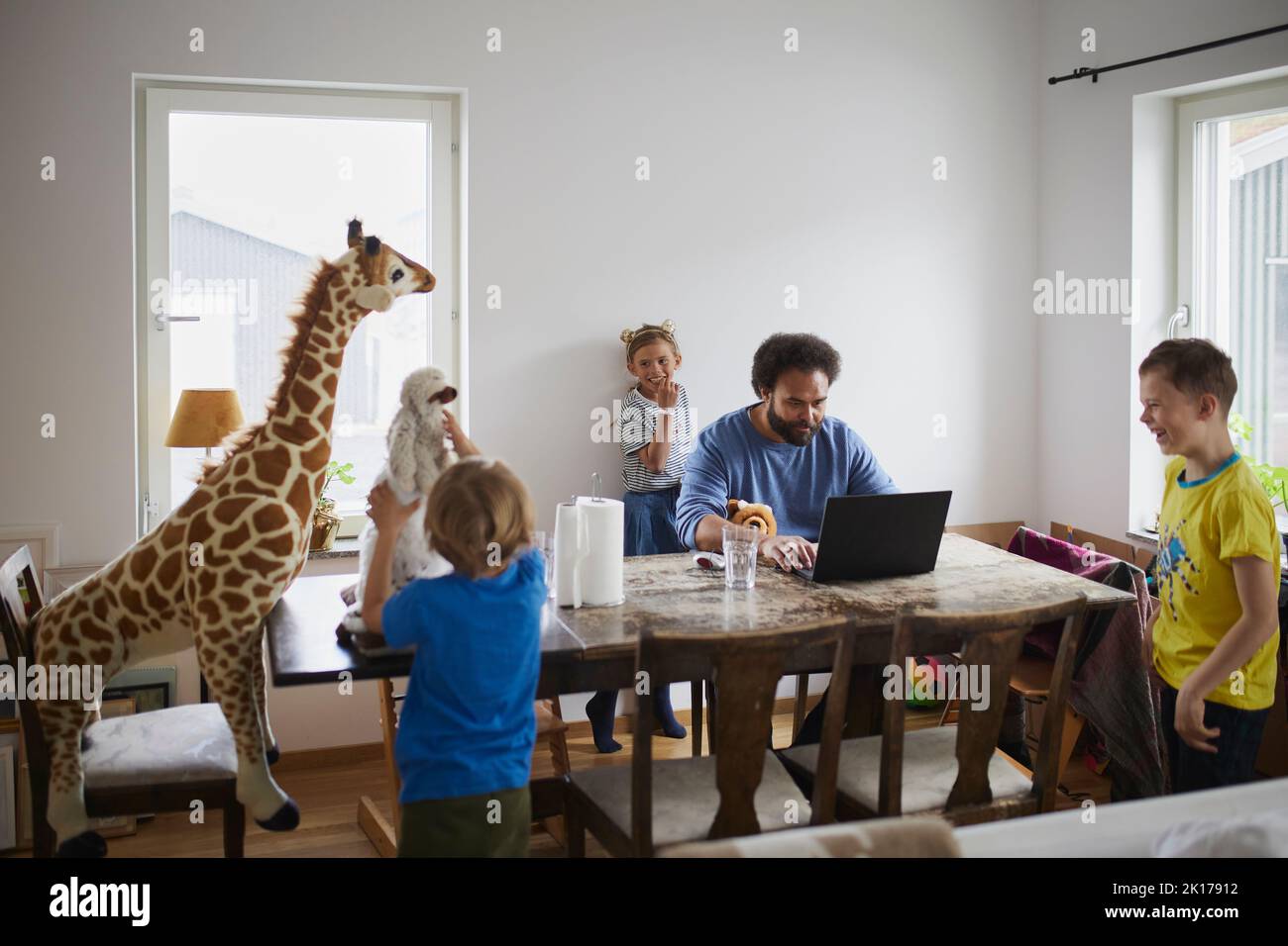 Father working from home and taking care of children Stock Photo