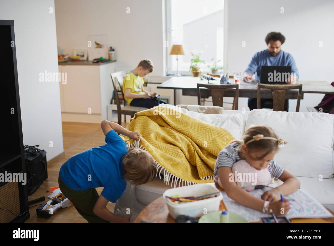 Children playing while father working from home Stock Photo