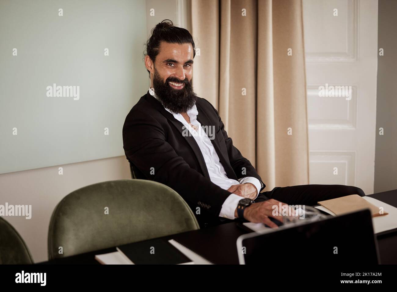 Smiling man sitting in boardroom Stock Photo