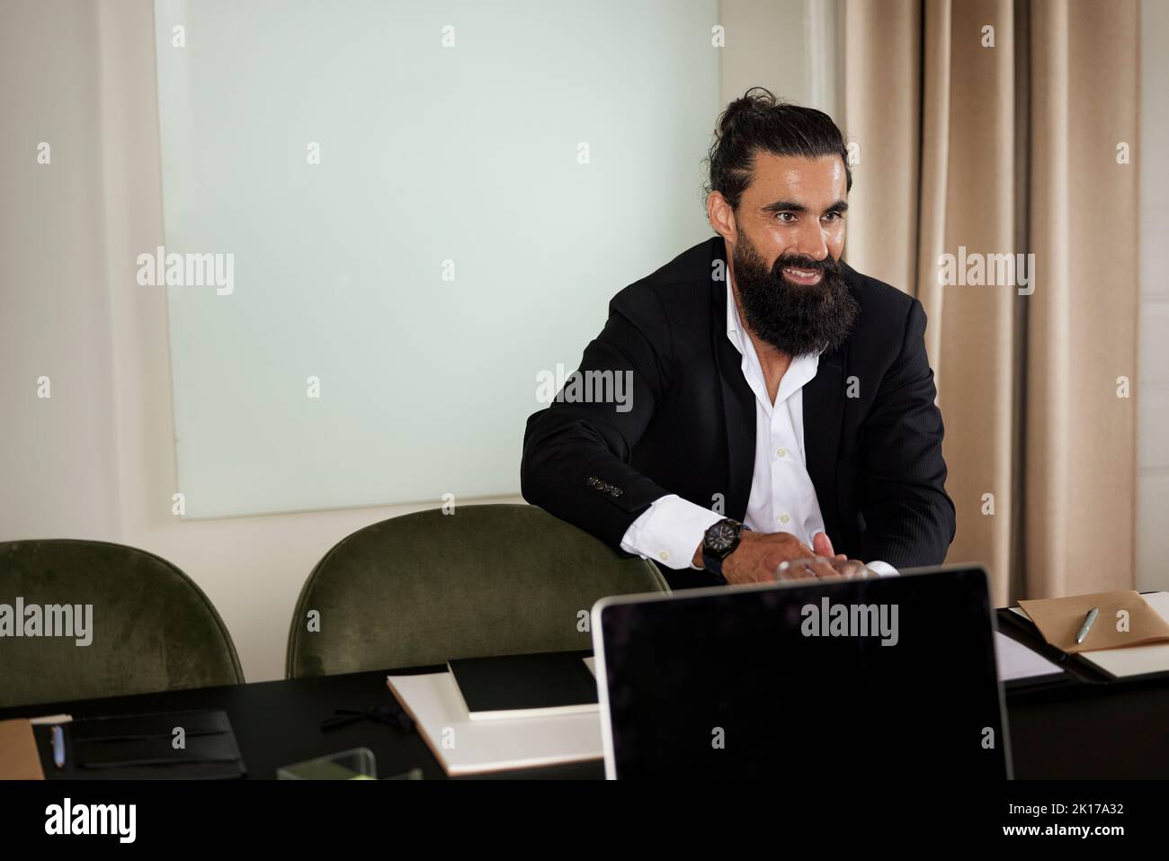 Smiling man sitting in boardroom Stock Photo
