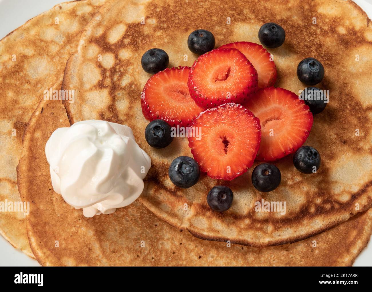 Pancakes with strawberries, blueberries and cream Stock Photo