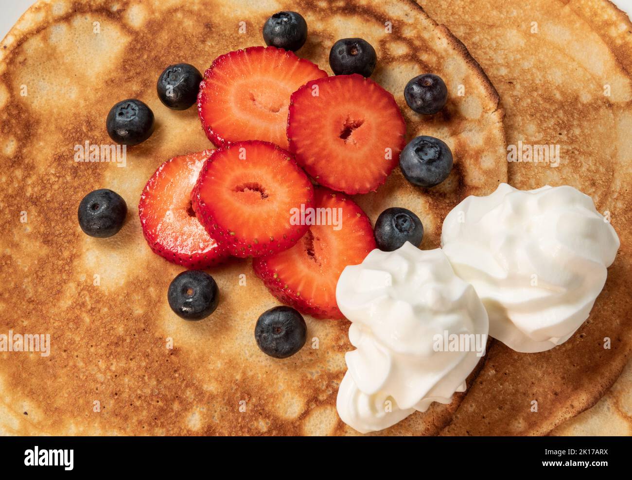 Pancakes with strawberries, blueberries and cream close up Stock Photo