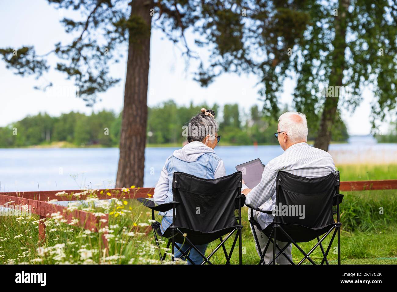 Senior couple sitting in camping chairs Stock Photo