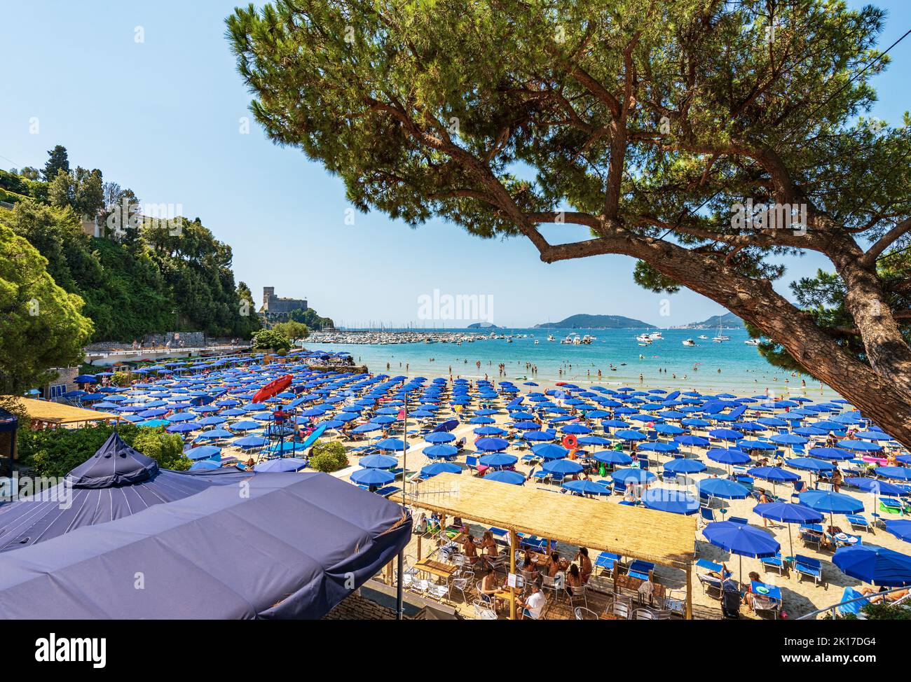 Lerici beach with many umbrellas, tourist resort on the coast of the Gulf of La Spezia, Liguria, Italy, Europe. Islands of Tino, Tinetto and Palmaria. Stock Photo