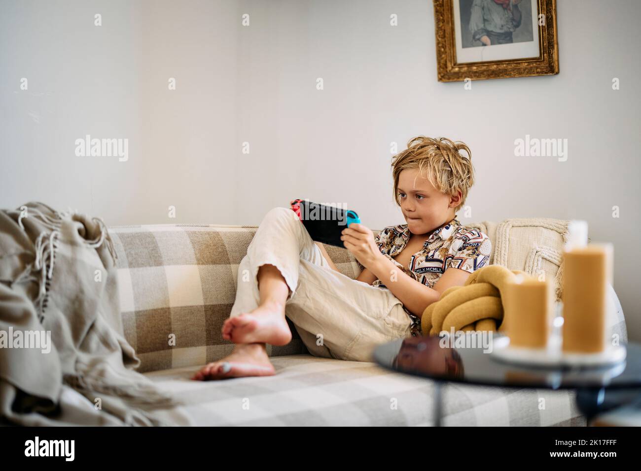 Boy on sofa using digital tablet Stock Photo