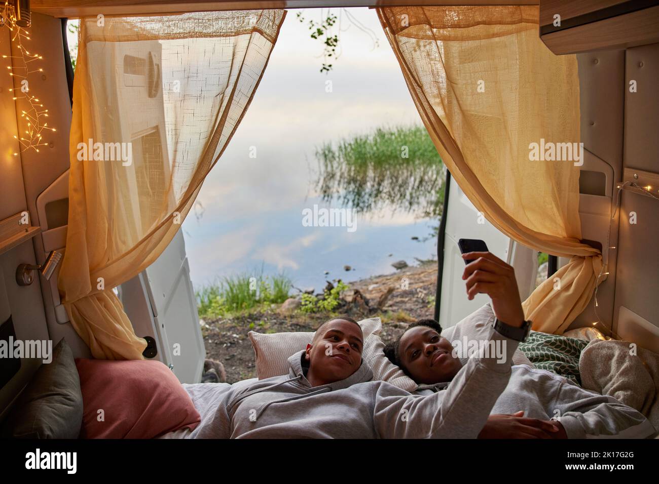Young couple taking selfie in camper van Stock Photo