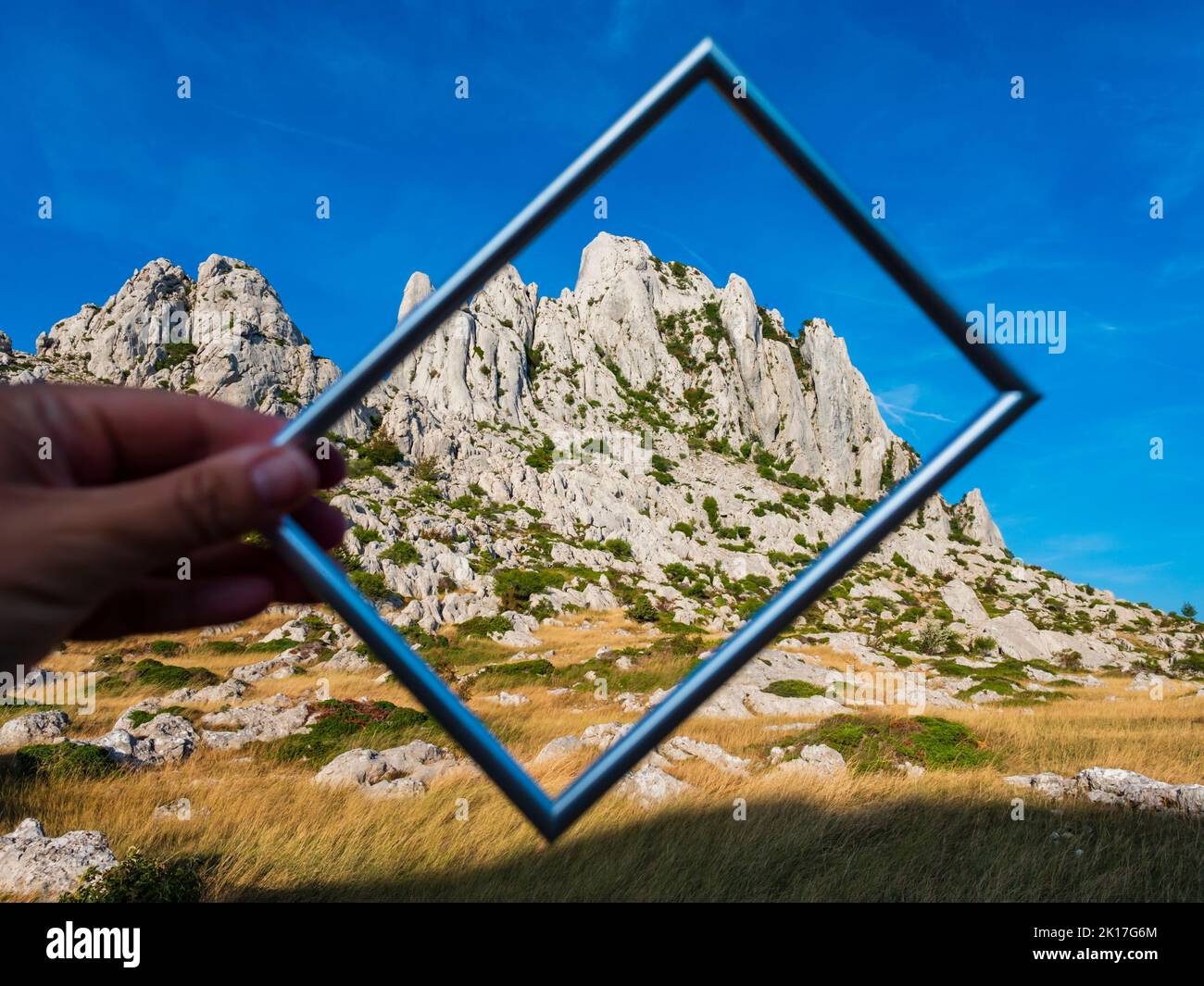 Hand holding hold picture frame of Tulove grede ridge mountain in Croatia Europe Stock Photo