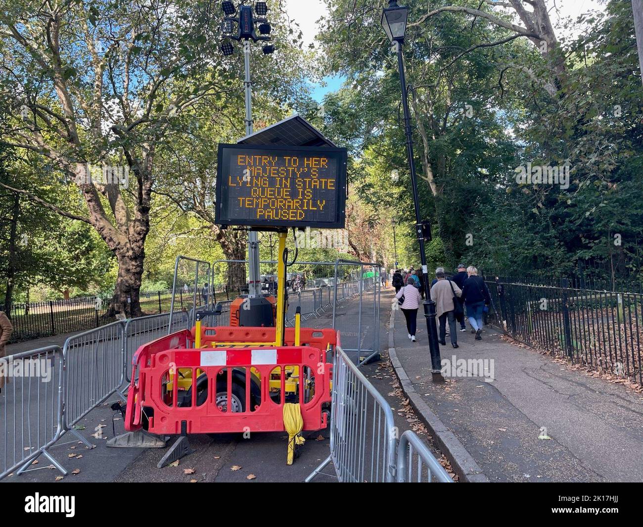 A sign outside Southwark Park in London announces that the queue to see the Queen has been paused as members of the public wait to view Queen Elizabeth II lying in state ahead of her funeral on Monday. Picture date: Friday September 16, 2022. Stock Photo