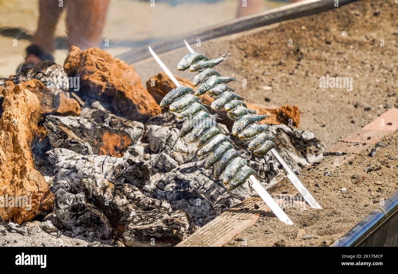 Sardines grilled on open wood fire, barbecue in Southern Spain on beach. Stock Photo