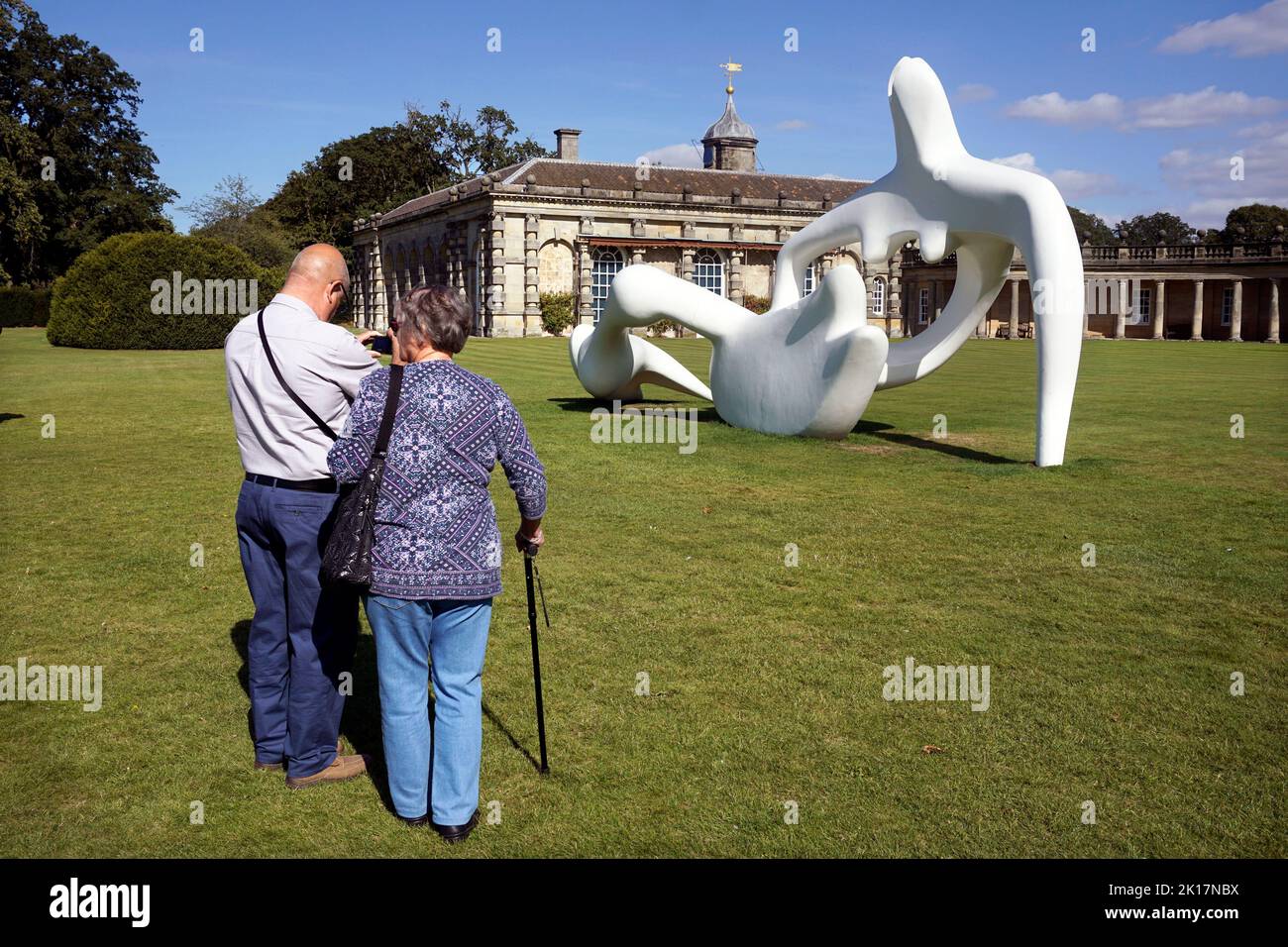 older couple photographing henry moore sculpture at houghton hall north norfolk england Stock Photo