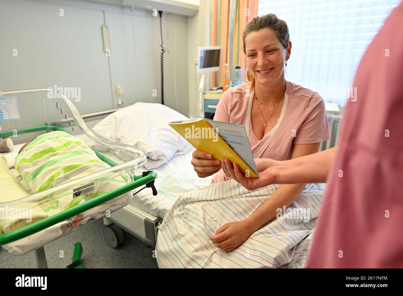 Nordhausen, Germany. 16th Sep, 2022. Anna Kellermann with her newborn son Louis is presented with a children's dental passport in the maternity ward of Südharz Klinikum Nordhausen. Since the summer of 2012, every newborn baby has received a dental child passport. In this passport, dentists document all check-ups and preventive measures in the dental practice, kindergarten and school during the first years of a child's life. Credit: Martin Schutt/dpa/Alamy Live News Stock Photo
