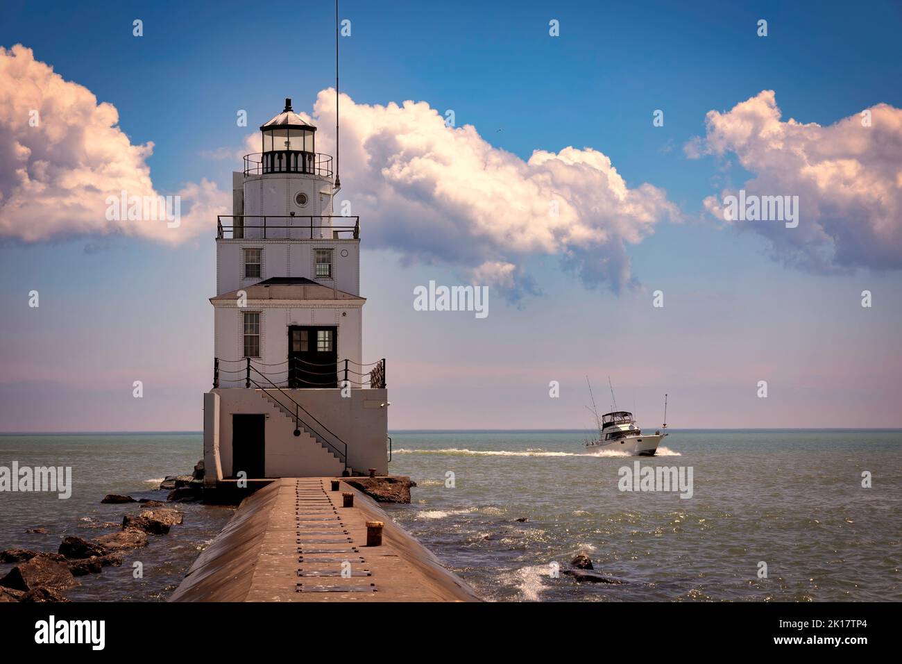 The lighthouse in Manitowoc, Wisconsin with a fishing boat returning from Lake Michigan on a summer day. Stock Photo