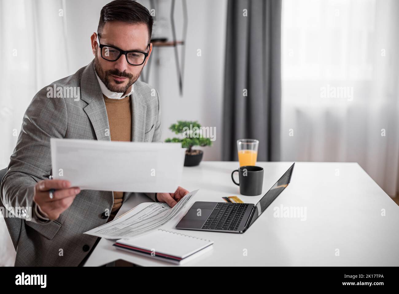 Focused young adult businessman, making sure his company is earning ...