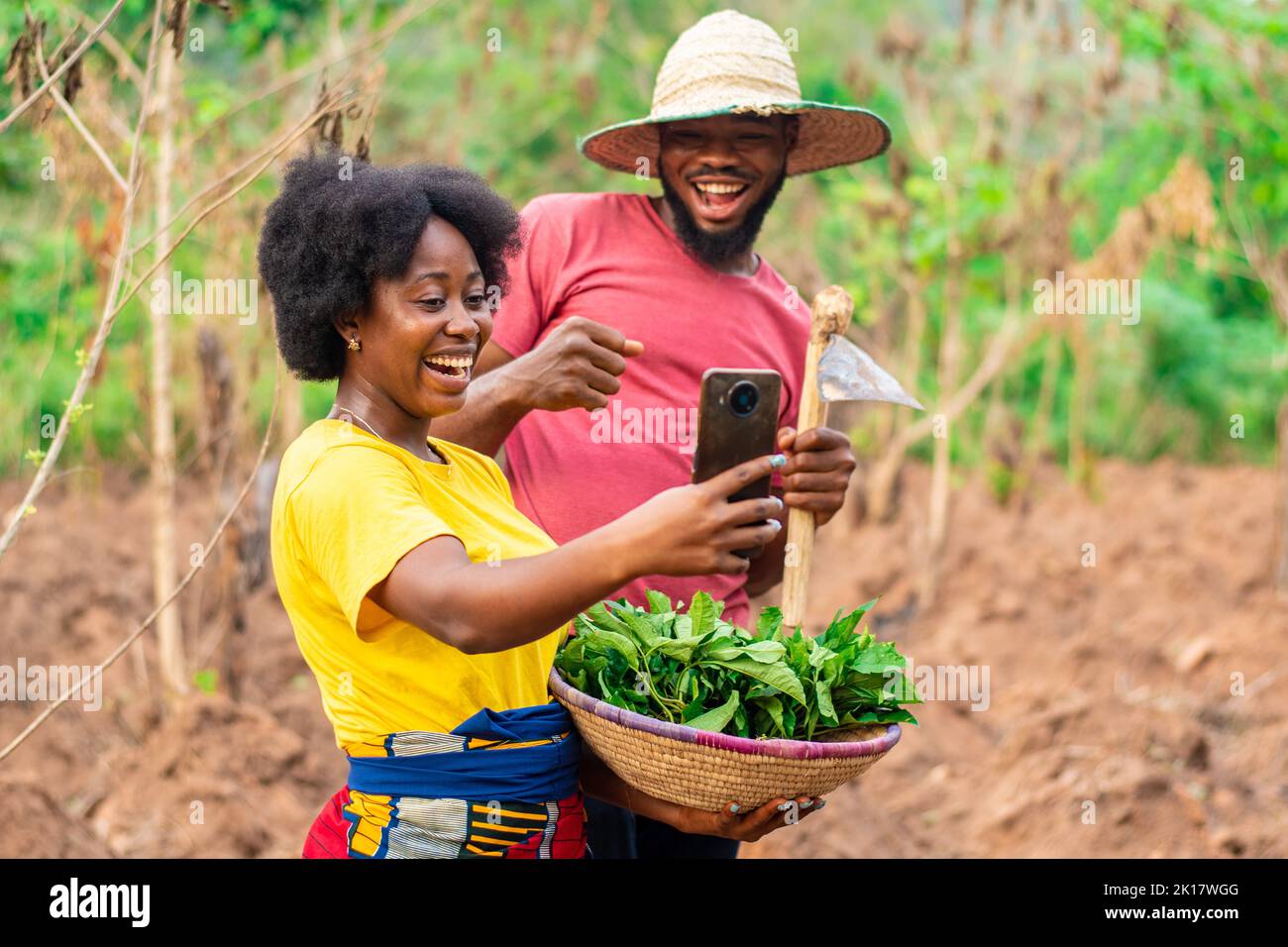 two african farmers excitedly looking at a phone Stock Photo