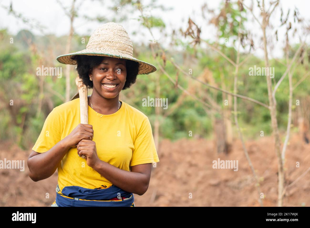 happy african farmer holding her hoe Stock Photo