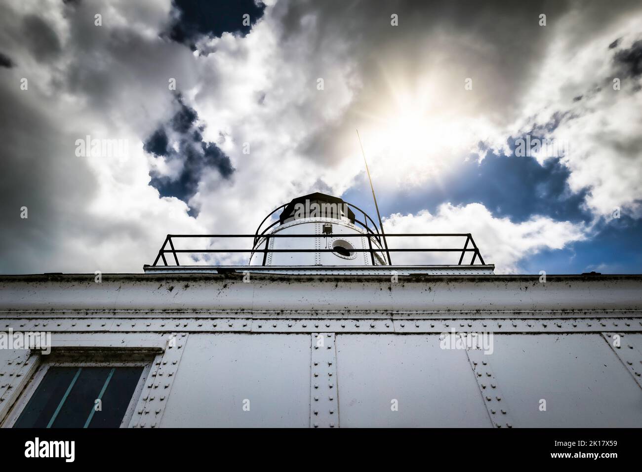 Looking up at the side of the lighthouse in Manitowoc, Wisconsin, built in 1918, while the sun peeks out. Stock Photo