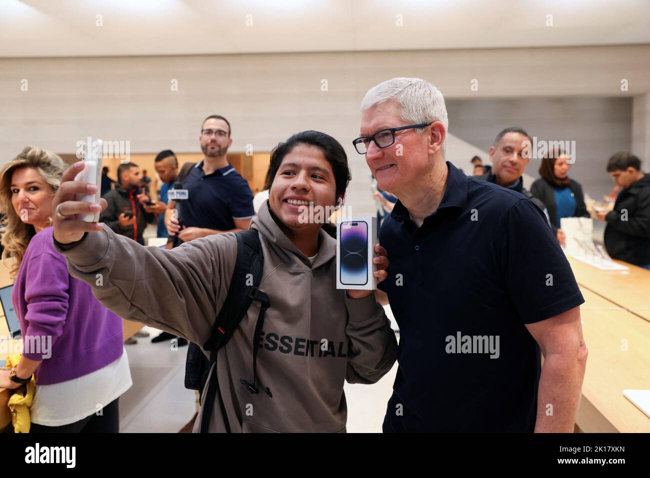 A customer takes a selfie with Apple CEO Tim Cook and an iPhone 14 Pro, at the Apple Fifth Avenue store, as Apple Inc's new iPhone 14 models go on sale, in Manhattan, New York City U.S. September 16, 2022. REUTERS/Andrew Kelly REFILE - CORRECTING INFORMATION Stock Photo