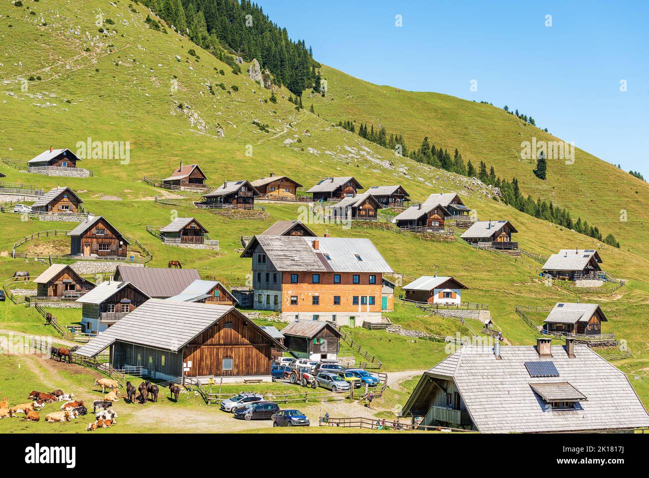 Village, Carnic Alps with herd of dairy cows and horses. Mountain peak of Osternig or Oisternig, Italy-Austria Border. Feistritz an der Gail, Austria. Stock Photo