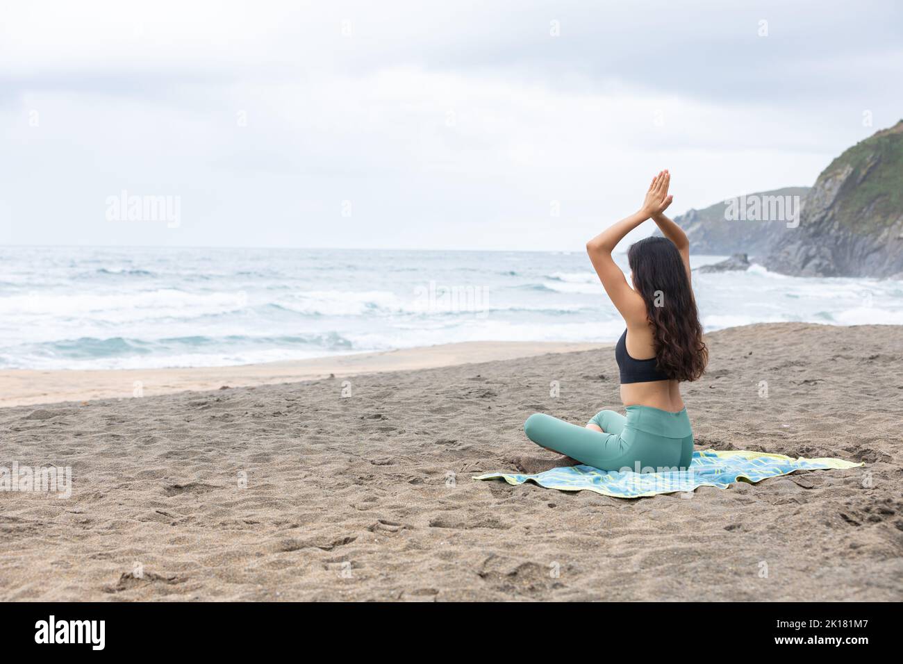 Fit young woman practicing yoga in Lotus pose on sandy seashore Stock Photo