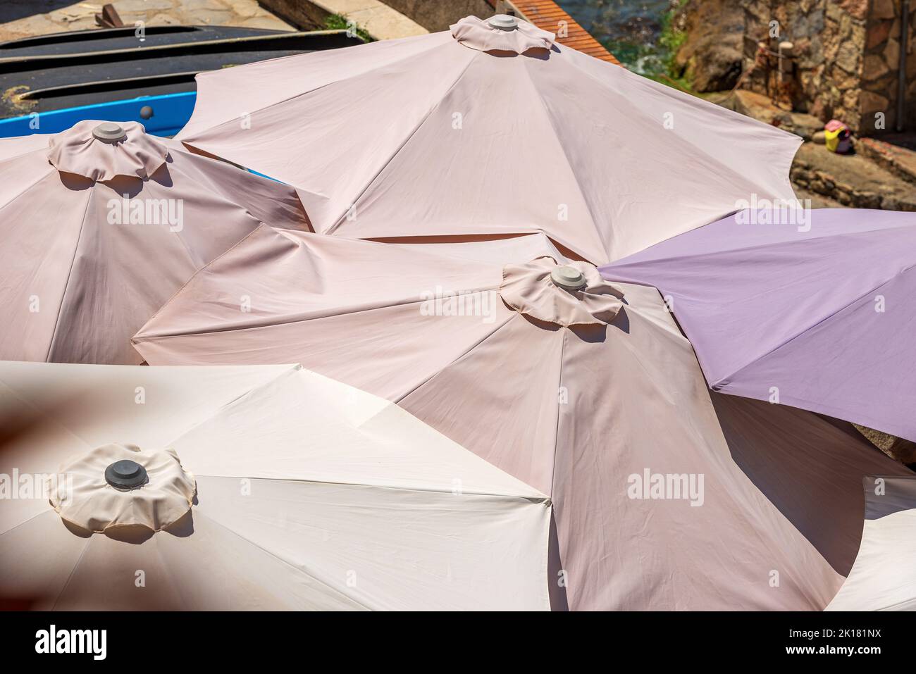 Close-up of a group of beach umbrellas seen from above, coast of Mediterranean sea, Liguria, Italy, Europe. Beach holiday concept or UV protection. Stock Photo