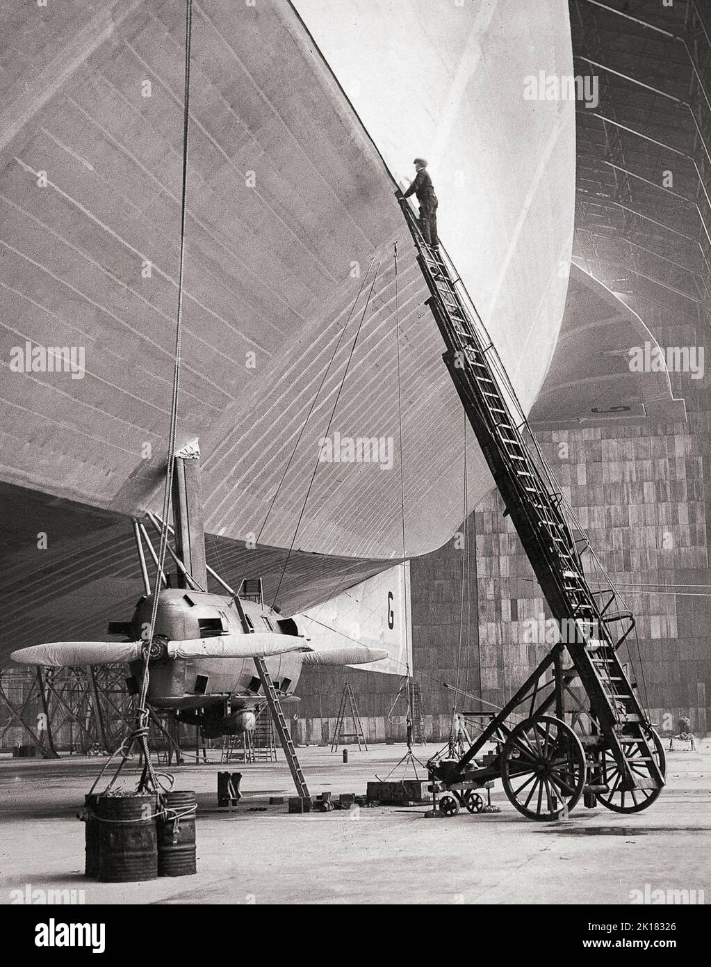Airship R100 nearing completion in its hanger in Yorkshire, England in 1929. It was a privately designed and built British rigid airship made as part of a two-ship competition to develop a commercial airship service for use on British Empire routes as part of the Imperial Airship Scheme. The other airship, the R101, was built by the British Air Ministry, but both airships were funded by the Government. Stock Photo
