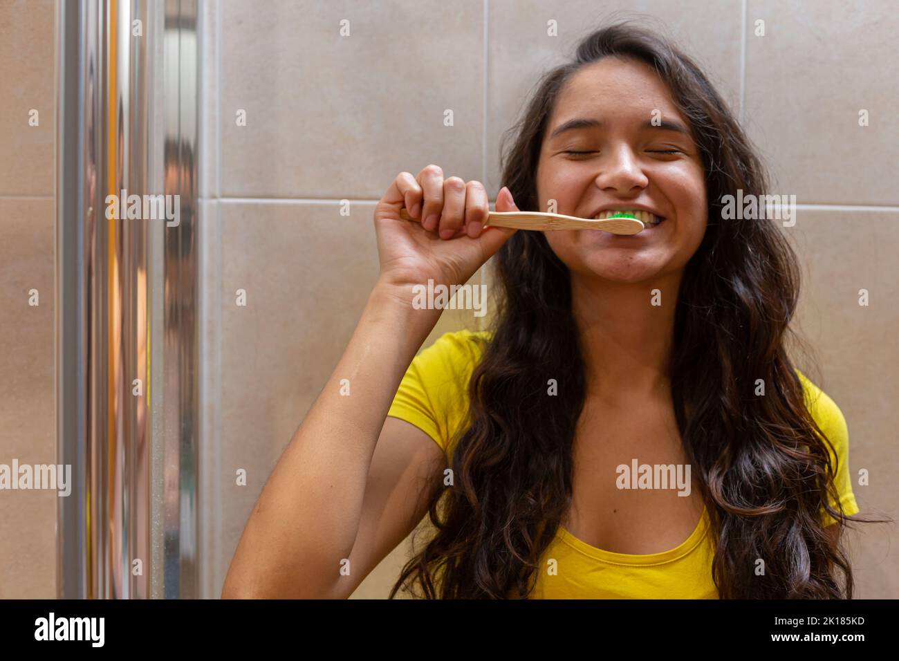 Young woman brushing teeth in bathroom Stock Photo