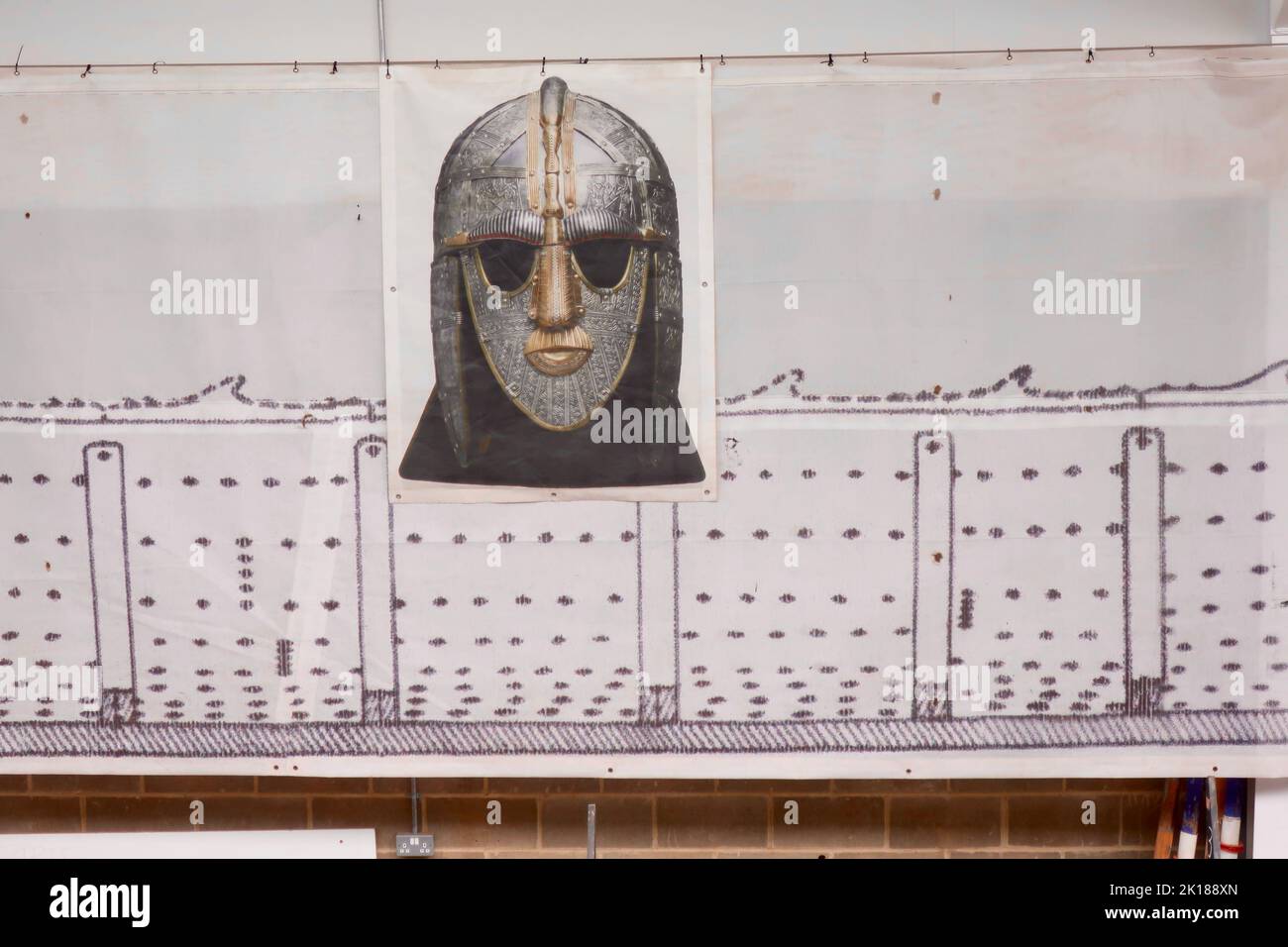 Woodbridge, Suffolk, UK - 16 September 2022 ; The Longshed boat building project at Whisstocks Square. Picture of the Sutton Hoo Anglo Saxon helmet on the wall. Stock Photo